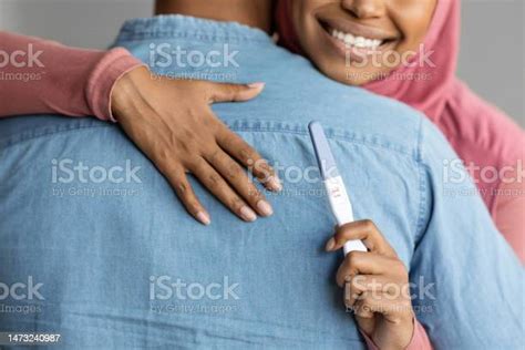 Black Muslim Woman In Hijab Holding Positive Pregnancy Test And