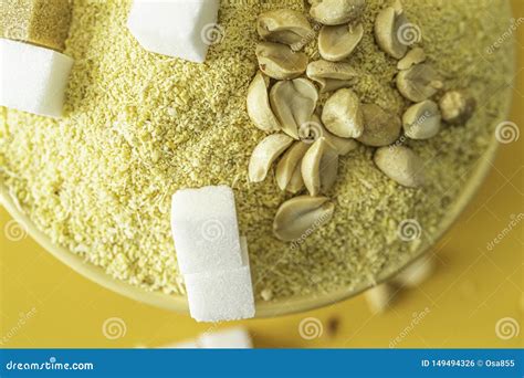 Bowl Of Nigerian Yellow Garri In Yellow Bowl With Peanuts And Sugar