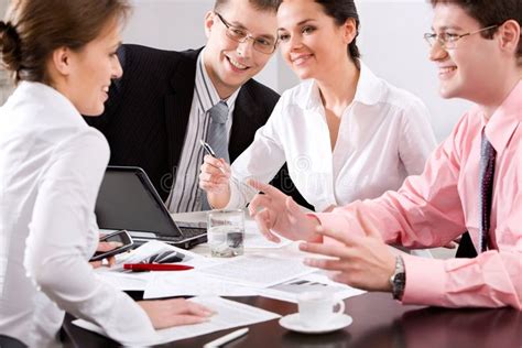 Teamwork Team Of Four Business People Sitting At The Table With Laptop