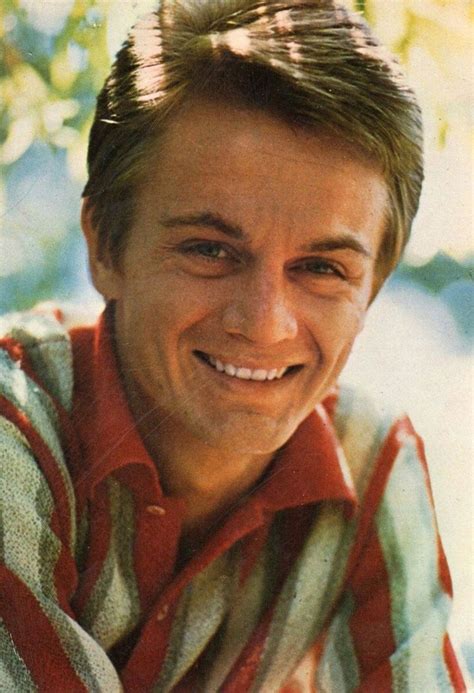 A Close Up Of A Person Wearing A Red And White Shirt Smiling At The Camera