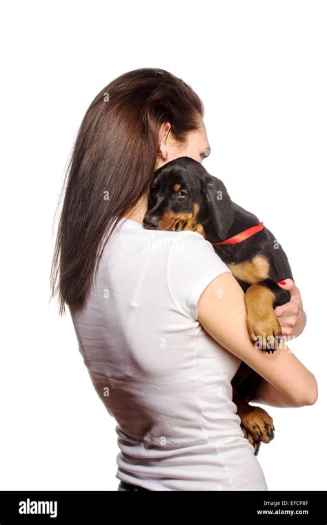 Brunette girl kissing her doberman puppy isolated on white background ...