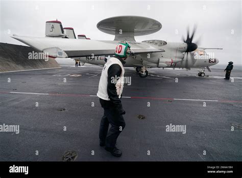 An Air Transfer Officer Watches The Wing Of An US Navy E 2 Hawkeye