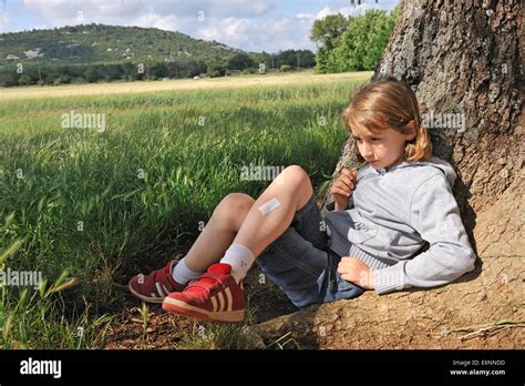 Little Girl Aged 9 Thinking Sitting Under A Tree Stock Photo Alamy