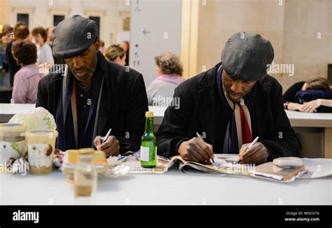 Two Identical Twins Sitting In Cafe Wearing The Same Clothes Writing