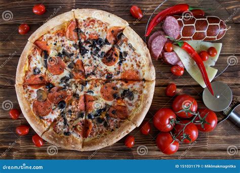 Pizza With Salami Pepperoni Olives And Mushrooms Lies On A Plank