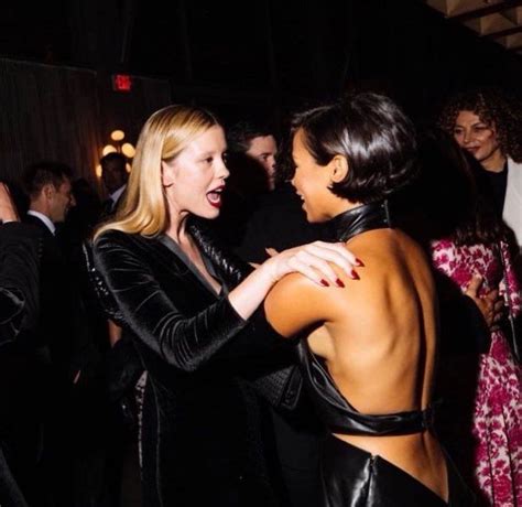 Two Women In Black Leather Outfits Dancing At A Party