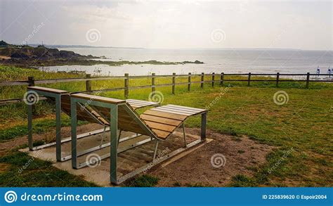 Empty Comfortable Benches Wet From Rainy Weather On A Cliff Overlooking