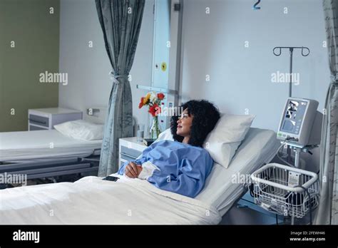 Smiling African American Female Patient Lying In Hospital Bed Looking