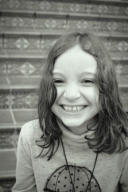 Premium Photo Portrait Of Smiling Girl Sitting Outdoors