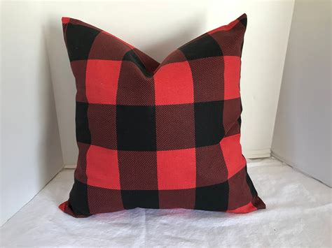 A Red And Black Pillow Sitting On Top Of A Bed