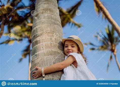 Petite Fille Heureuse Embrassant Un Palmier Pendant Des Vacances