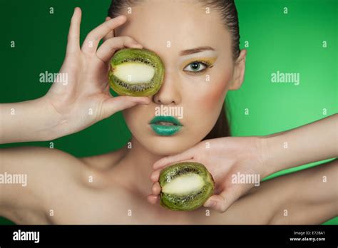 Beauty Portrait Of A Girl With Kiwi On A Green Background Stock Photo