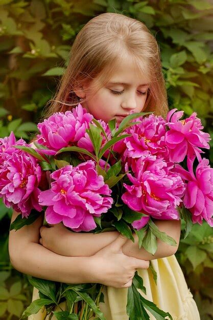 Premium Photo A Beautiful Blonde Girl With Long Hair Holds A Bouquet Of Pink Peonies In Her Hands