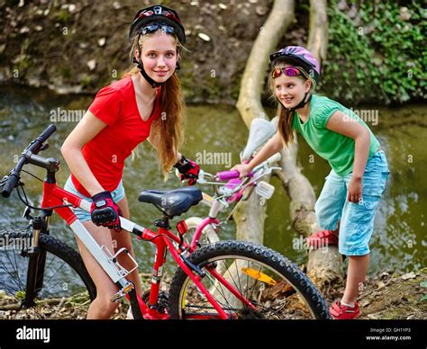 Girl On Bicycle Fording Throught Water Onto Log In Park Stock Photo Alamy