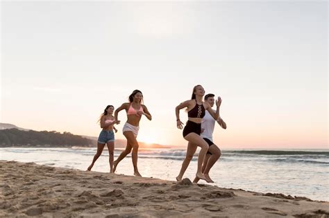 Amigos De Tiro Completo Corriendo En La Playa Foto Gratis