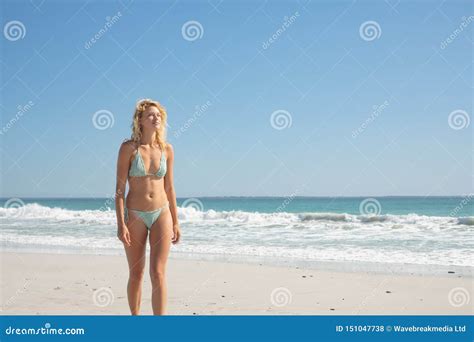 Woman In Bikini Walking On The Beach In The Sunshine Stock Photo