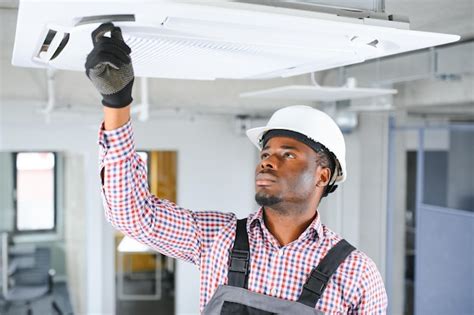 Premium Photo African Male Technician Repairing Air Conditioner