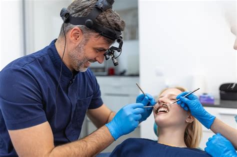 Femme Brune Souriante En Cours D Examen Par Un Dentiste La Clinique