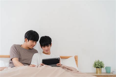 jeune couple gay asiatique utilisant une tablette à la maison Photo de stock chez Vecteezy
