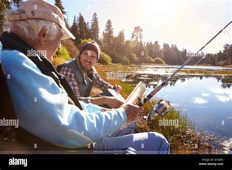 Father And Adult Son Fishing Lakeside Close Up Stock Photo Alamy