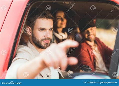 Handsome Young Man Pointing Somewhere While Riding Car Stock Photo