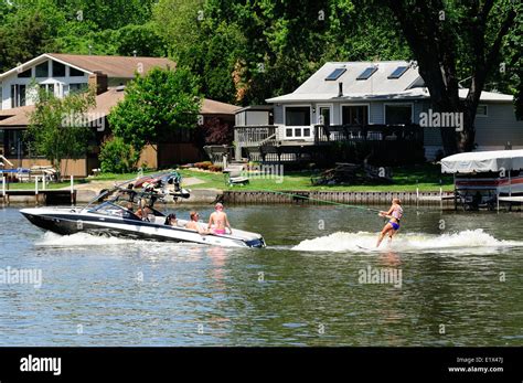 Group of young people wake surfing behind boat Stock Photo - Alamy