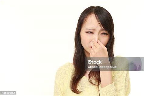 Japanese Woman Holding Her Nose Because Of A Bad Smell Stock Photo