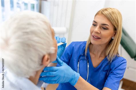 Senior Patient Opening Her Mouth For The Doctor To Look In Her Throat