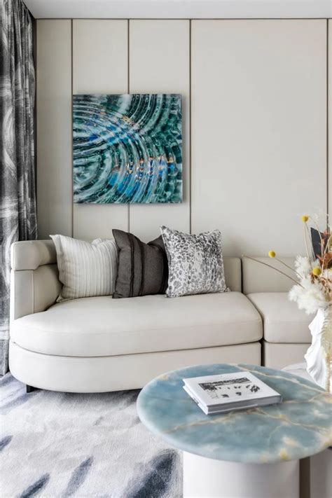 A Living Room Filled With Furniture And A Large Painting On The Wall