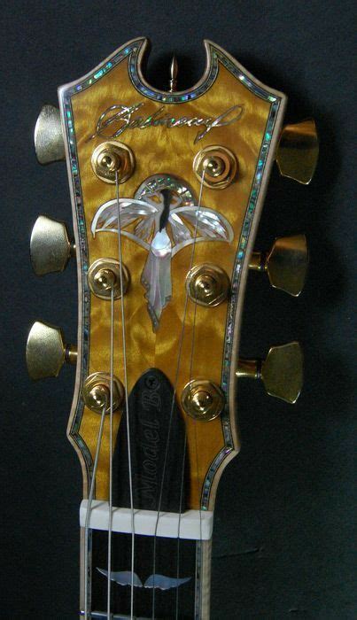 An Old Guitar Has Been Decorated With Gold And Silver Decorations On It