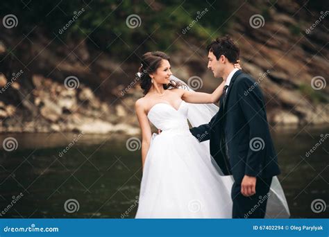 Beautifull Wedding Couple Kissing And Embracing Near The Shore Of A