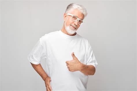 Premium Photo Portrait Of Mature Man In White Tshirt And Glasses Smiling Joyfully Showing