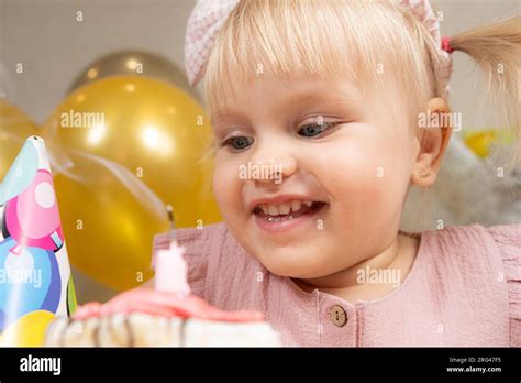 A Two Year Old Girl Blows Out A Candle On A Birthday Cake Makes A Wish