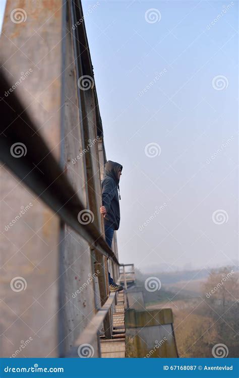 Sad Young Man Standing on the Edge of a Bridge. Looking Away Thinking ...