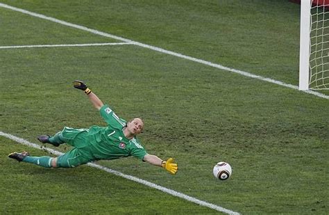 A Soccer Player Dives To Catch The Ball