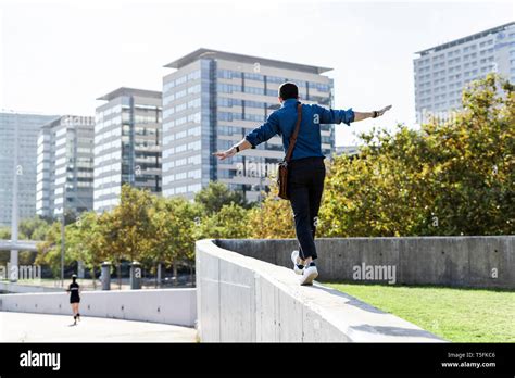 Back View Of Man Balancing On Wall Stock Photo Alamy