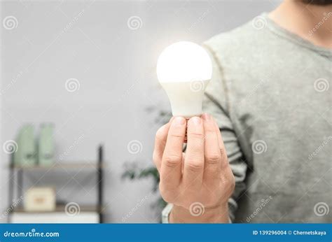 Man Holding Lamp Bulb On Blurred Background Stock Photo Image Of