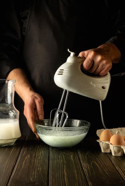 Premium Photo The Chef Uses A Handheld Electric Mixer To Prepare A Delicious Breakfast Or