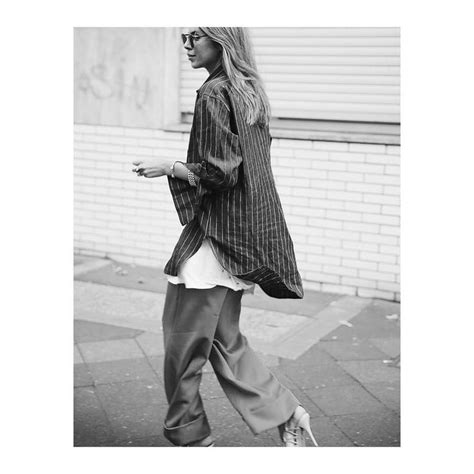 Black And White Photograph Of Woman Walking Down The Street With Her