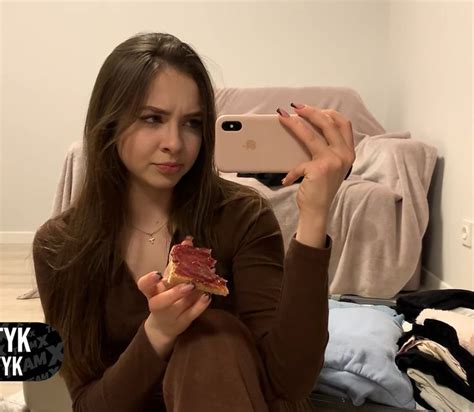 A Woman Sitting On The Floor Holding A Piece Of Food