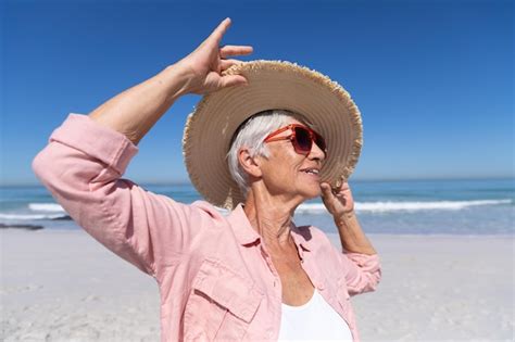 Mujer caucásica mayor disfrutando del tiempo en la playa en un día