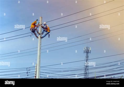 Electrician Lineman Repairman Worker At Climbing Work On Electric Post