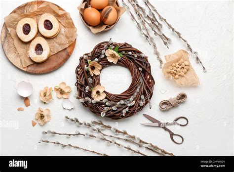 Composition With Beautiful Easter Wreath Pussy Willow Branches Eggs And Cookies On Light