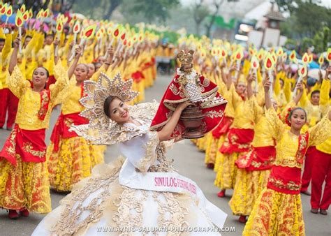 A Group Of People Dressed In Yellow And Red Dresses Are Marching Down