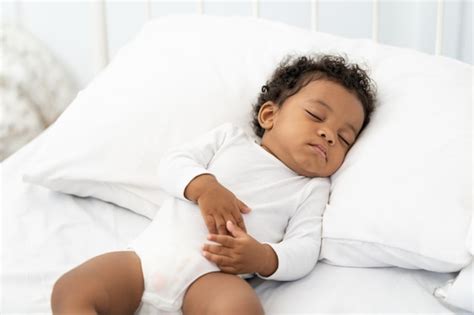 Premium Photo Black African American Baby Sleeping On A White Mattress