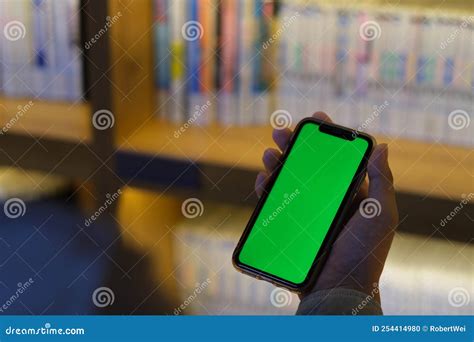 Hand Holding Green Screen Smart Phone In Library Stock Photo Image Of