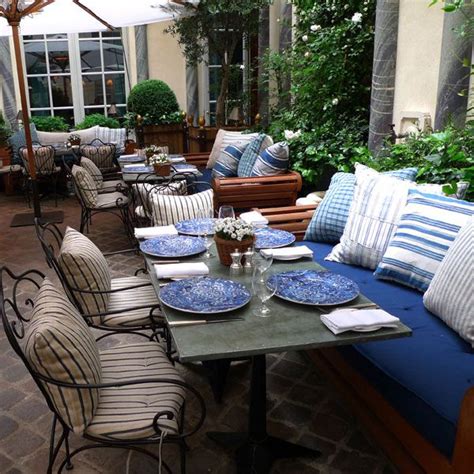 an outdoor seating area with blue and white plates on top of the table ...