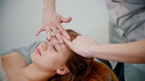 Massage Woman Massage Therapist Massaging The Face Of A Red Haired