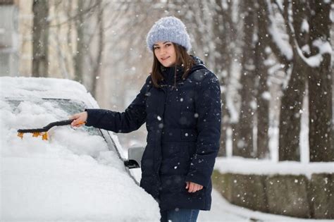 Premium Photo Woman Removing Snow From Car Windshield