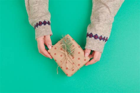 Premium Photo Woman Hands Holding Gift Box On Green